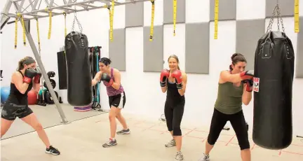  ??  ?? Trois membres du Sportex accompagné­s de leur instructri­ce Rachelle Thibodeau lors d’une séance de boxe.