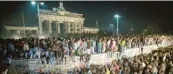  ?? Archiv-Foto: Peter Kneffel, dpa ?? Am Brandenbur­ger Tor kletterten in der Nacht vom 9. auf 10. November 1989 viele Menschen in Berlin auf die Mauer vor dem Brandenbur­ger Tor. Denn an diesem Abend ging die Mauer in Berlin auf.