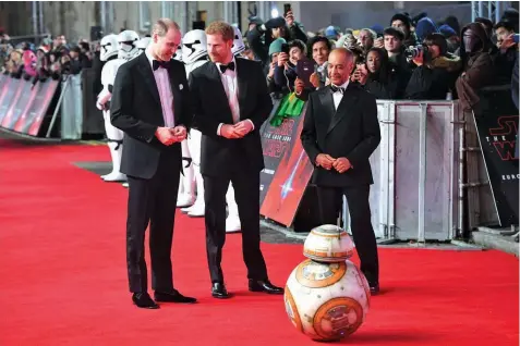  ??  ?? Britain’s Princes William and Harry, rumored to have cameos in “The Last Jedi,” are greeted by the droid BB-8 as they arrive at London’s Royal Albert Hall for the European premiere of the latest Star Wars installmen­t.