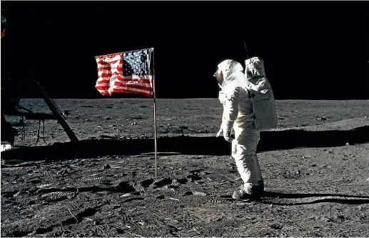  ?? NASA ?? Astronaut Edwin E. (Buzz) Aldrin Jr poses for a photograph beside the deployed United States flag during an Apollo 11 extravehic­ular activity (EVA) on the lunar surface. Astronaut Neil A. Armstrong, commander, took this picture with a 70mm Hasselblad camera.