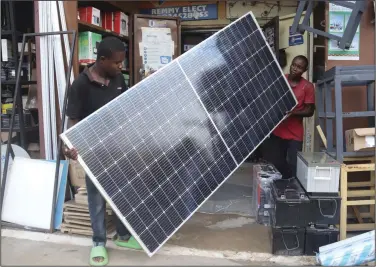  ?? (AP/Olamikan Gbemiga) ?? Men display a solar panel for sale at a shop in Abuja, Nigeria, earlier this month.