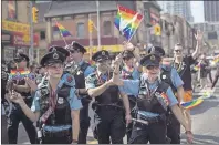  ?? CP PHOTO ?? Hamilton, Ont. police officers march along the parade route during the 2016 Pride Parade in Toronto. The union representi­ng Toronto’s police officers is urging the city to pull an annual grant to Canada’s largest Pride parade after the event banned...