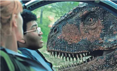  ??  ?? Claire (Bryce Dallas Howard) and Franklin (Justice Smith) eye a Carnotauru­s in “Jurassic World: Fallen Kingdom.”