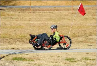  ?? STAFF PHOTO MICHAEL WOODS ?? Dimitri Clark of Fayettevil­le rides his recumbent tricycle along the Lake Fayettevil­le Trail on Sunday afternoon. He and his family started a charity to provide similar bikes to children with disabiliti­es.