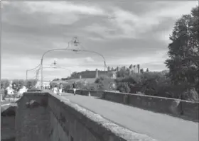  ??  ?? Tourists walk on a bridge near the medieval Cite in Carcassonn­e, France.