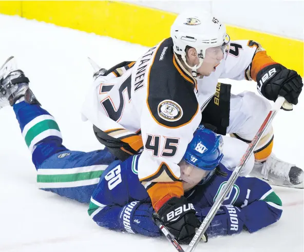  ?? — THE CANADIAN PRESS ?? Anaheim Ducks defenceman Sami Vatanen, top, falls on Vancouver Canucks forward Markus Granlund Thursday during the Ducks’ 3-1 victory at Rogers Arena. Ryan Miller kept the Canucks in the game early on, but it wasn’t enough for a point.