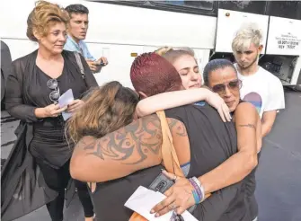  ?? CRISTOBAL HERRERA/ EPA- EFE ?? Students from Marjory Stoneman Douglas High School and community members hug before students board buses in Parkland, Fla., to head to the state capital to meet with lawmakers over gun violence.