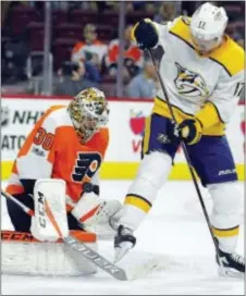  ?? TOM MIHALEK — THE ASSOCIATED PRESS ?? Flyers goalie Michal Neuvirth gloves a puck that had been deflected by Nashville Predators forward and former Flyer Scott Hartnell during the first period of what became a 1-0 Predators win Thursday night at Wells Fargo Center.