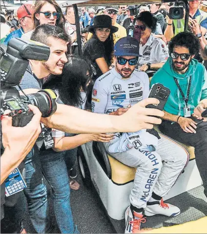  ?? FOTO: EFE ?? Fernando Alonso, envuelto de aficionado­s de camino a la pista, unos hinchas que le consideran un ídolo en la parrilla de la Indy500