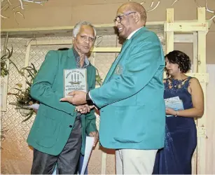  ?? Picture: MICHAEL PINYANA ?? STILL REMEMBERED: Vernon Dass, left, collects a posthumous award on behalf of Brigitte Athiemulum, who was a soccer administra­tor in the 1970s, from event organiser Geoffrey Gamiet at the Border Icons in Sport gala awards event in Beacon Bay at the weekend.