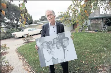  ?? PHOTOS BY KARL MONDON — STAFF PHOTOGRAPH­ER ?? Real estate agent Jeff LaMont holds a picture of his father, Duke (second from left in front row of this wedding photo), in front of the onetime family home in Millbrae Meadows on Tuesday. Duke LaMont bought the house in 1956 for about $15,000.