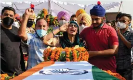  ??  ?? Sandeep Kaur and her brother Prabhjot Singh lay flowers on the coffin of their father, Satnam Singh, who was killed in the fight in the Galwan Valley. Photograph: Narinder Nanu/ AFP/Getty Images