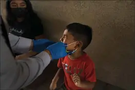  ?? JAE C. HONG — THE ASSOCIATED PRESS ?? Shahir Sanchez, 5, grimaces as Dr. Neal Schwartz collects a nasal swab sample for COVID-19testing at Families Together of Orange County in Tustin on Thursday.