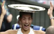  ?? STEVEN PASTON, THE ASSOCIATED PRESS ?? Garbine Muguruza jokes with her trophy as she leaves the court after beating Venus Williams in the women’s singles final at the Wimbledon tennis championsh­ip in London on Saturday. Muguruza won 7-5, 6-0.