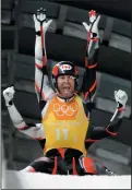  ?? AP PHOTO/ANDY WONG ?? Tristan Walker and Justin Smith, of Canada, react in the finish area after Canada won silver in the luge team relay.