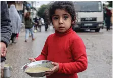  ?? AFP ?? A displaced child carries a ration of red lentil soup, distribute­d by volunteers in Rafah, southern Gaza Strip, amid the conflict between Israel and Hamas.