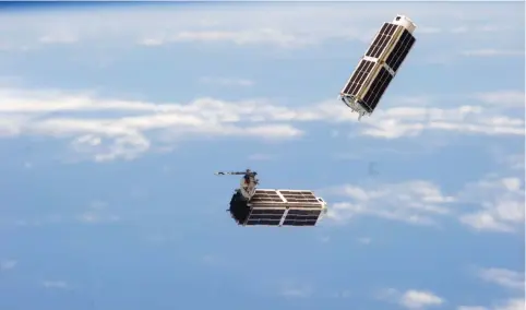  ?? (NASA) ?? A SET OF NanoRacks CubeSats is photograph­ed by an Expedition 38 crew member after the deployment by the Small Satellite Orbital Deployer (SSOD). The CubeSats program contains a variety of experiment­s such as Earth observatio­ns and advanced electronic­s...