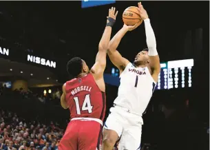  ?? MIKE KROPF/AP ?? Virginia’s Jayden Gardner shoots over North Carolina State’s Casey Morsell during Tuesday night’s game in Charlottes­ville. Gardner led the Cavaliers with 18 points.