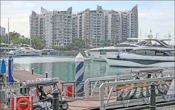  ?? — AFP photo ?? Photo shows Sentosa Cove private residentia­l housing next to yachts docked at One 15 Marina Sentosa Cove in Singapore.