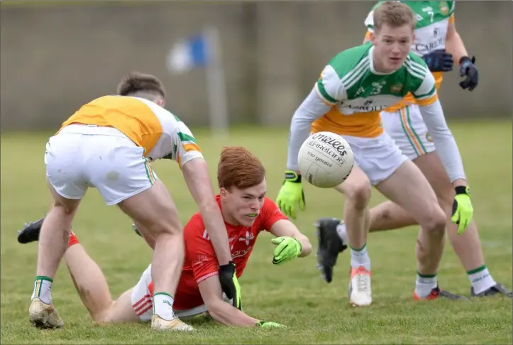 ?? Pictures: Ken Finegan ?? Ciaran Keenan of Louth gets the ball away despite close attention from Offaly players.