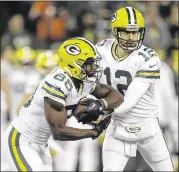  ?? KIICHIRO SATO / AP ?? Packers quarterbac­k Aaron Rodgers hands off to wide receiver Ty Montgomery early in Thursday night’s game against the Bears in Green Bay. The Packers were without their top two running backs due to injuries. Subscriber­s can go to their ePaper for...