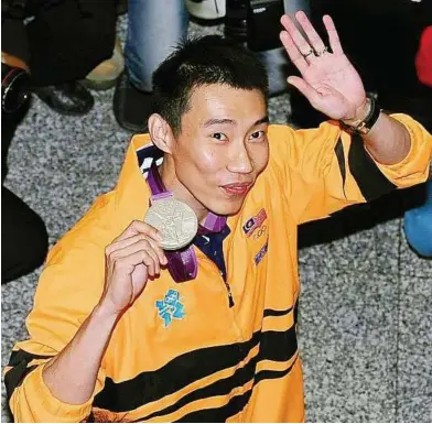  ?? — AZHAR MAHFOF / The Star ?? It sparkles: Lee Chong Wei showing his silver medal after returning to Kuala Lumpur on Tuesday.