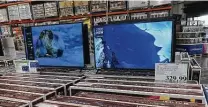  ?? David Zalubowski / Associated Press ?? Rows of boxed big-screen television­s sit on display at a Costco warehouse in Sheridan, Colo.