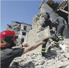  ?? ANDREW MEDICHINI / THE ASSOCIATED PRESS ?? Firefighte­rs retrieve a painting from a church in the small town of Rio, near Amatrice, central Italy, which was hit by a devastatin­g earthquake last week.