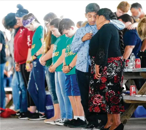  ?? Elizabeth Conley / Staff file photos ?? Attendees bow their heads in prayer last year during a candleligh­t vigil for the one-year anniversar­y of the Santa Fe High School shooting. In the attack on May 18, 2018, a gunman barged into the school and killed eight students and two teachers and injured 13 others.