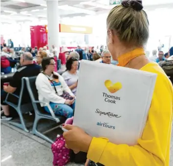  ?? Foto: Francisco Ubilla, dpa ?? Eine Mitarbeite­rin des britischen Reisekonze­rns Thomas Cook informiert britische Passagiere am Flughafen Palma de Mallorca. Die britische Regierung wollte noch am Montag nach der Insolvenz der Gesellscha­ft mindestens 14000 Urlauber in ihre Heimat zurückbrin­gen.