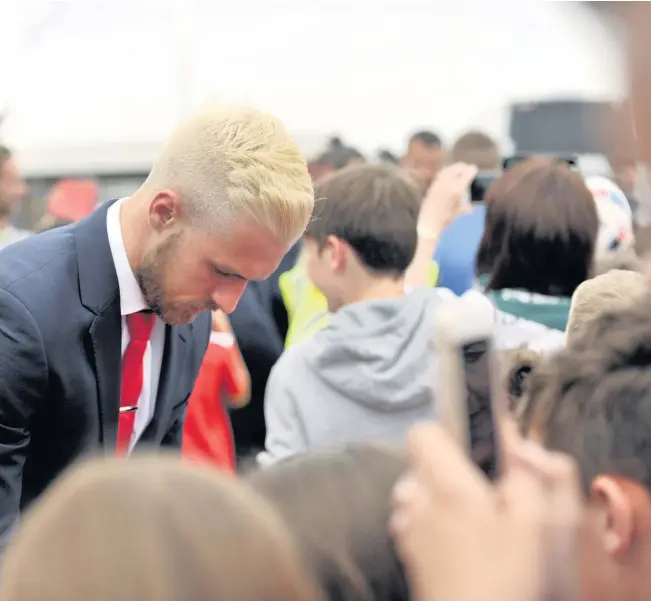  ??  ?? Aaron Ramsey, pictured dishing out the autographs prior to Wales’ departure from Cardiff Airport yesterday, has been the subject of high praise from boss Chris Coleman of late