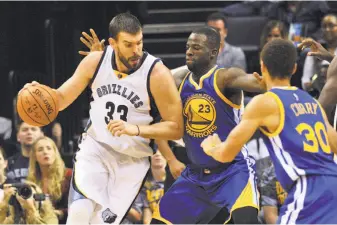  ?? Brandon Dill / Associated Press ?? Marc Gasol (left), guarded by Draymond Green and Stephen Curry, had 26 points and seven rebounds, but Memphis lost by 16 — better, at least, than the 50-point drubbing on Nov. 2.