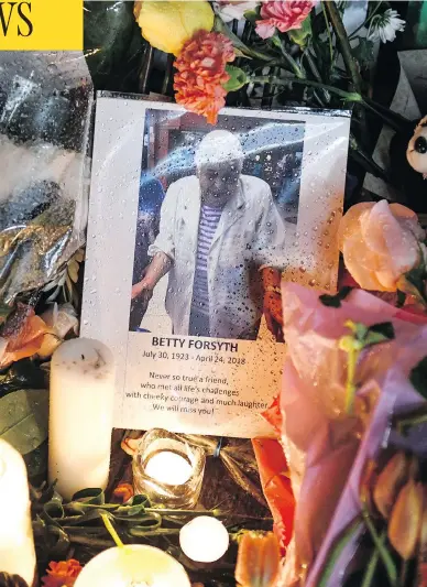  ?? GALIT RODAN / THE CANADIAN PRESS ?? A photo of Betty Forsyth is nestled among flowers and candles at a vigil on Yonge Street in Toronto Tuesday evening. The 94-year-old was one of 10 victims killed Monday when a van ran onto a sidewalk and targeted pedestrian­s.