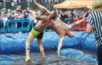  ?? OLI SCARFF/ AGENCE FRANCE-PRESSE ?? Competitor­s take part in the 10th annual World Gravy Wrestling Championsh­ips held at the Rose ’n’ Bowl Pub near Bacup, northwest England on Monday. Contestant­s participat­e in fancy dress and wrestle in a pool of Lancashire Gravy for two minutes while...