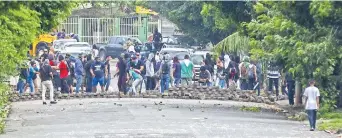  ??  ?? Manifestan­tes desmontan una barricada en un barrio de la capital de Nicaragua. Ayer, grupos paramilita­res arrasaron con varias barricadas que opositores habían levantado en cuatro populosos barrios de la zona oriental de la capital.