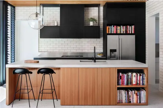  ??  ?? KITCHEN This galley-style layout mixes concrete and stainless-steel elements with blackbutt veneer in natural and black-stained finishes. Miele cooktop and Electrolux fridge. Gessi tapware. Gubi ‘3D’ stools, Surroundin­g. The chopping board was an engagement present. Platter, Marmoset Found. Classicon ‘Selene’ pendant light, Anibou. LIVING ROOM Daphne at the blackbutt desk/large shelf – handy for homework, Lego play and sewing. Floor cushion, Country Road. Vitra ‘Potence’ wall light, Space. Artwork by Sam Michelle. Design classic: Feathersto­n ‘B210’ armchair, from $4590, Grazia &amp; Co.