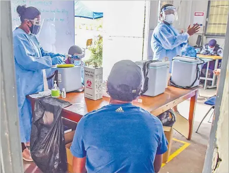  ?? Picture: ATU RASEA ?? Staff nurse Sangeeta Sharma (left) and fellow nurses attend to the public during a vaccinatio­n drive at the FNU campus in Nasinu.