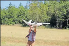  ?? [JAMEY JACOB/OKLAHOMA STATE UNIVERSITY] ?? An Oklahoma State University researcher helps launch a drone for a Vigilant Aerospace Systems flight test. Vigilant is developing software that will allow drones to fly and navigate autonomous­ly.