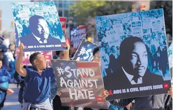  ?? BRANDON WADE/FORT WORTH STAR-TELEGRAM ?? Marchers in a Martin Luther King Day parade in Fort Worth, Tex., celebrate King’s legacy on Monday as leaders condemn as racist a remark attributed to President Donald Trump last week.