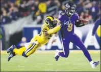  ?? The Associated Press ?? RAM TAKEDOWN: Baltimore Ravens quarterbac­k Lamar Jackson, right, is tackled by Los Angeles Rams defensive end Dante Fowler during the second half of Monday’s game in Los Angeles.