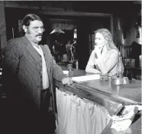  ?? AP FILE PHOTO BY KEVORK DJANSEZIAN ?? Actors Ian McShane, who portrays Al Swearengen, and Paula Malcomson, who portrays Trixie, prepare for a scene on the set of HBO’s ‘Deadwood’ in 2005 in Santa Clarita, Calif. HBO greenlight­ed Wednesday a long-discussed movie based on the western drama...