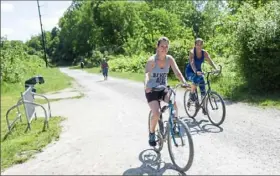  ?? Emily Matthews/Post-Gazette ?? Diana Repack, left, and Lisa Jacobs, both of Moon, ride their bikes on the Montour Trail in June in Robinson.