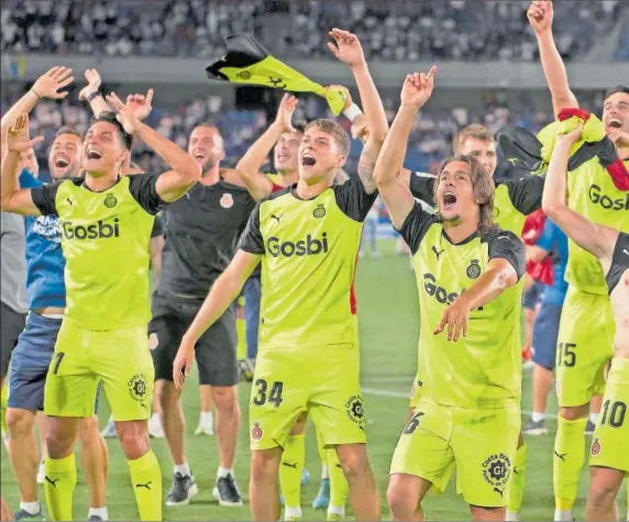  ?? ?? Los jugadores del Girona celebran con sus aficionado­s la vuelta a Primera sobre el césped del Heliodoro.