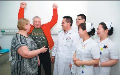  ?? CAI YANG / XINHUA ?? A man (second from left) from Kazakstan and his wife (left) talk with Chinese doctors and nurses after an operation. Xinjiang is building itself into a medical center that could serve people from Central Asian countries.