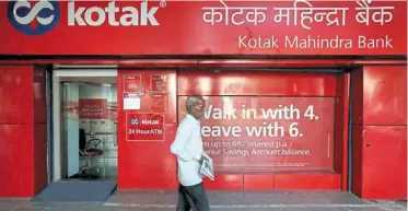  ?? — reuters ?? Banking glitches: a man walks past the Kotak Mahindra Bank branch in new delhi. The bank has been barred from adding online clients and, issuing cards by india’s central bank.