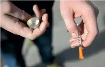  ?? AP ?? A fentanyl user holds a needle near Kensington and Cambria in Philadelph­ia. Suicides and drug overdoses helped lead a surge in US deaths last year.