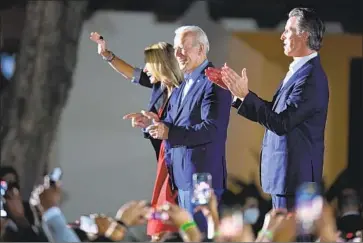  ?? Wally Skalij Los Angeles Times ?? PRESIDENT BIDEN walks onstage with Gov. Gavin Newsom and his wife, Jennifer Siebel Newsom, on Monday at Long Beach City College. Biden’s stop in California marked the closing campaign act for the governor.