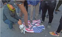  ?? ASSOCIATED PRESS FILE PHOTO ?? Baghdad protesters step on a U.S. flag before burning it last month during the funeral of Iran’s top Gen. Qassem Soleimani, who was killed in a U.S. airstrike. Some of the flags used in such protests are manufactur­ed in Iran.