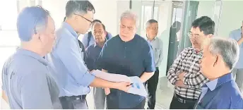  ??  ?? Awang Tengah (centre) and Liaw (second left) checking out a possible location of Stato Brunei in Bandar Seri Begawan.