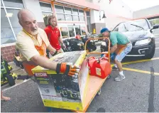  ?? AP PHOTO/KEN BLEVINS ?? Jim Craig, David Burke and Chris Rayner load generators as people buy supplies at The Home Depot in Wilmington, N.C., in September. Home Depot Inc. exceeded expectatio­ns in its earnings report Tuesday.